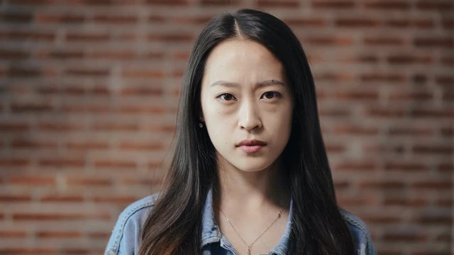 Portrait of young asian girl looking at the camera with a tired look