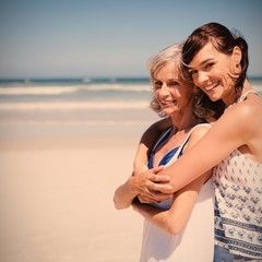 Portrait of happy woman embracing her mother at beach