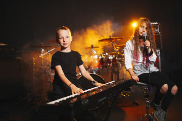 Fototapeta na wymiar children singing and playing music in recording studio