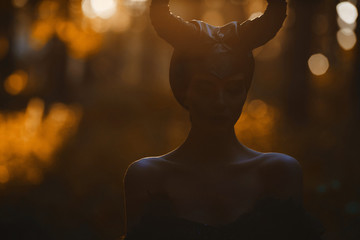 Dark portrait of a beautiful and sensual brunette model girl in the image of a mythical creature -...