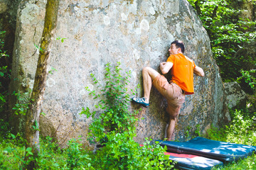 Naklejka na ściany i meble The climber is climbing bouldering.