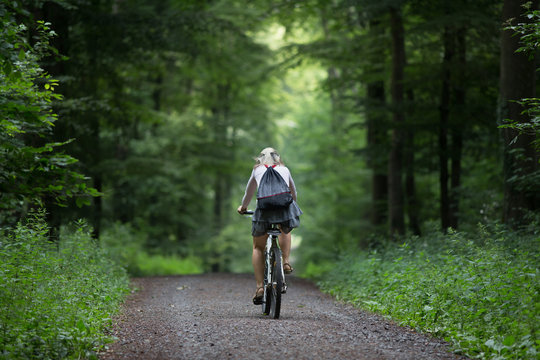 Older woman on bicycle in forest
