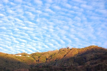 Beautiful clouds and houses on hills at sunrise on a sunny day in Cingjing, Nantou, Taiwan