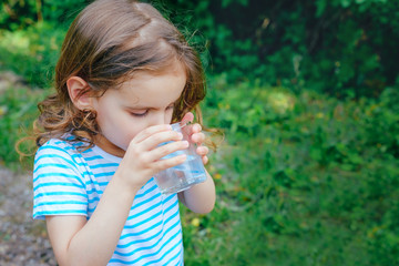 child drinks water on a Sunny summer day. selective focus.