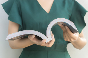 Close Up hand of Woman wearing green dress open book for reading concept.