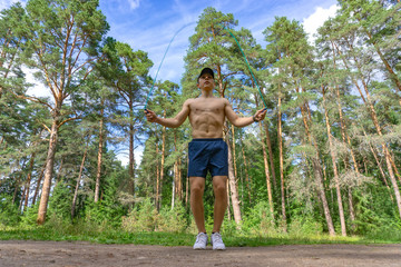 Young man jumping rope in the park