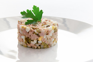 cod liver salad decorated with parsley leaf