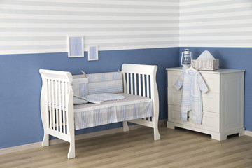 Interior of light cozy baby room with crib and bedding