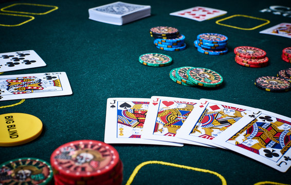 Grüner Casino Poker Tisch mit Spielkarten, ein Vierling Buben und bunten Chips. Konzept Glück und Risiko