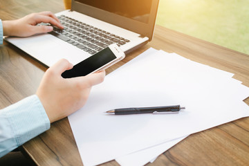 Close-up of Business woman working with smartphone,laptop and document in coffee shop like the background.