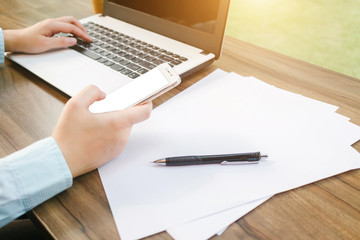 Close-up of Business woman working with smartphone,laptop and document in coffee shop like the background.