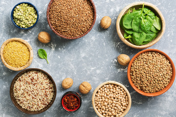 A source of protein and vitamins,a variety of legumes and cereals. Buckwheat, peas, chickpeas,bulgur,buckwheat,brown rice,lentils, spinach. Top view, gray background. flat lay