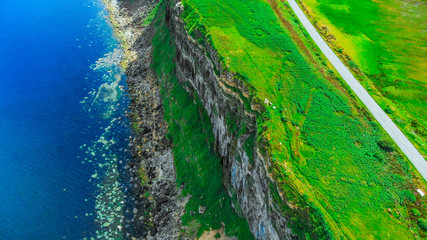 Aerial view over the green coastline and cliffs on the Isle of Skye in Scotland
