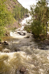 Fototapeta premium nature landscape landscape mountains valley hills rocks cave water waterfall stream river stream rock stone sky grass trees green blue white tourism excursions Russia,