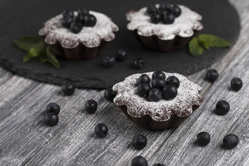 Cake with blueberry and sugar powder on the table.