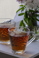 Two glasses of tea and flowers