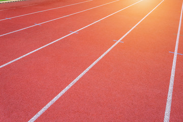 White lines of stadium and texture of running racetrack red rubber racetracks in outdoor stadium are 8 track and green grass field,empty athletics stadium with track.