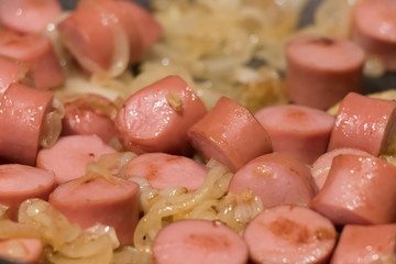 Skillet of sausage and onion rings on the stove