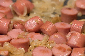 Skillet of sausage and onion rings on the stove