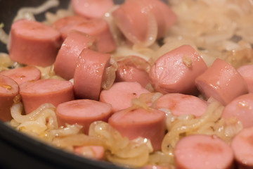 Skillet of sausage and onion rings on the stove