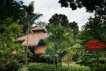 Vintage Straw thatched roof cottage in tropical forest garden, Kanchanaburi, Thailand