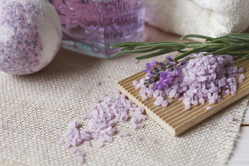 Lavender flowers, lavender soap, aromatic sea salt and towels. Concept for spa, beauty and health salon, cosmetics store. Close up photo on white wooden background.