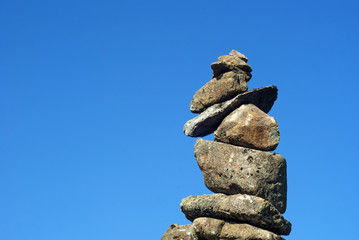 perfectly balanced pyramid of wild stones against the sky