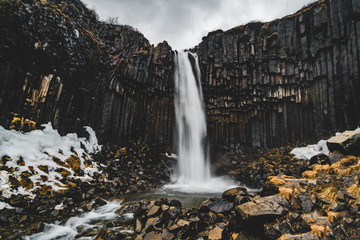 Dramatic morning view of famous Svartifoss (Black Fall) Waterfall. Colorful summer sunrise in...
