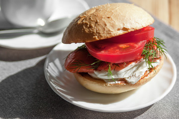 Sandwich with fresh salmon, tomato and cream cheese, a delicious breakfast