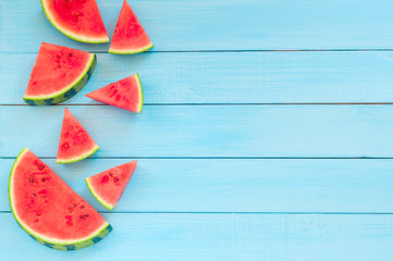 Watermelon slices on a turquoise wooden background, top view, copy space