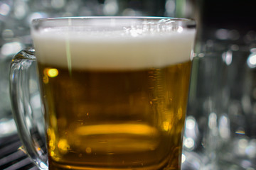 close-up of barman hand at beer tap pouring a draught lager beer