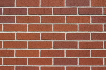 Reddish brown brick wall background in traditional running bond pattern