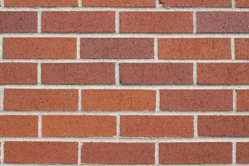 Reddish brown brick wall background in traditional running bond pattern