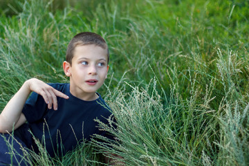 boy with cerebral palsy lies in the grass outdoors