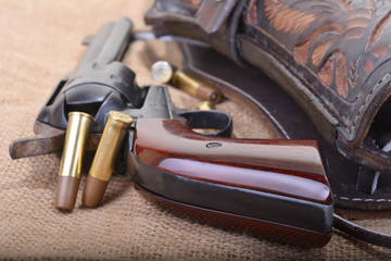 Close up of a western six shooter revolver with leather holster aand bullets