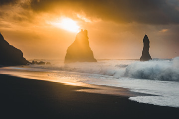 Sunrise at famous Black Sand Beach Reynisfjara in Iceland. Windy Morning. Ocean Waves. Colorful...