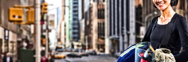 Composite image of female architect holding helmet and gloves