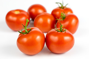 Red tomatoes on a white table. Tasty vegetables for the best dishes in the kitchen.