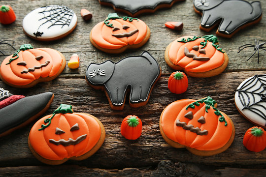 Halloween gingerbread cookies with candies on wooden table