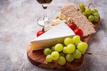Cheese plate with brie, grape and wine