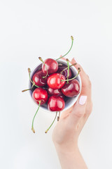 Obraz na płótnie Canvas Fresh ripe cherry in a bowl with woman hands