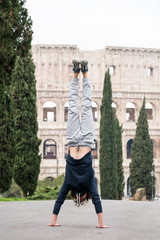 Young guy doing handstand while training in the park