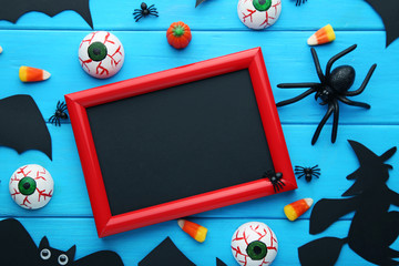 Halloween candy corns with wooden frame on blue table