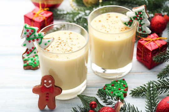 Eggnog in glasses with gingerbread cookies on wooden table