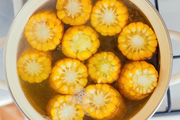 the process of making sweet corn in a pot on the gas stove at home