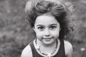 Black and white Portrait of cute little girl smiling outside