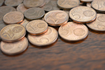 Euro cent coins. 1 euro, 2 euro and 5 euro cent coins on wood table.