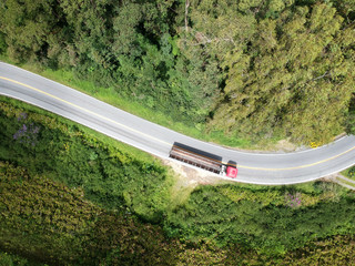 A drone upper view picture of a curve road in brazil with a truck