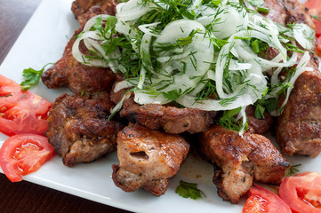 Fried skewers on the grill in a white dish