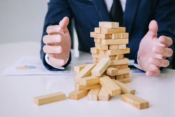 Alternative risk concept, plan and strategy in business protect with balance wooden stack with hand...